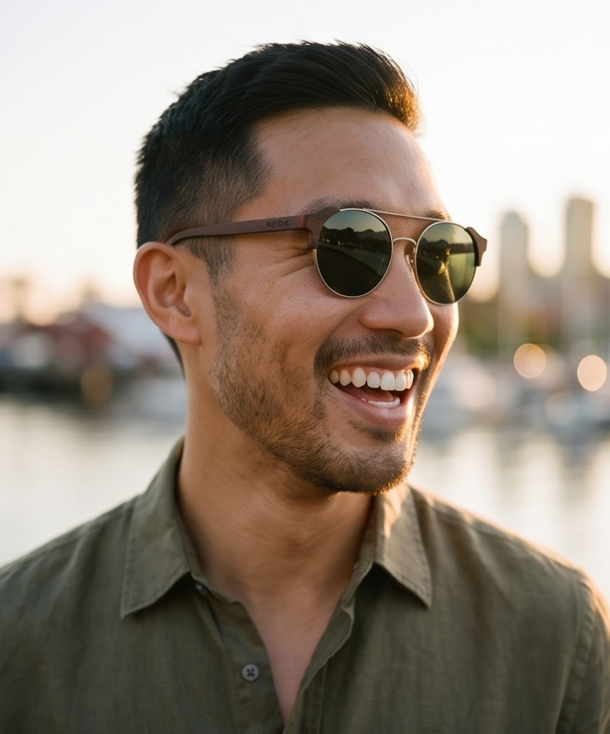 Man by a city waterfront wearing Atacama Ebony sunglasses by Kobe Afrika, close-up