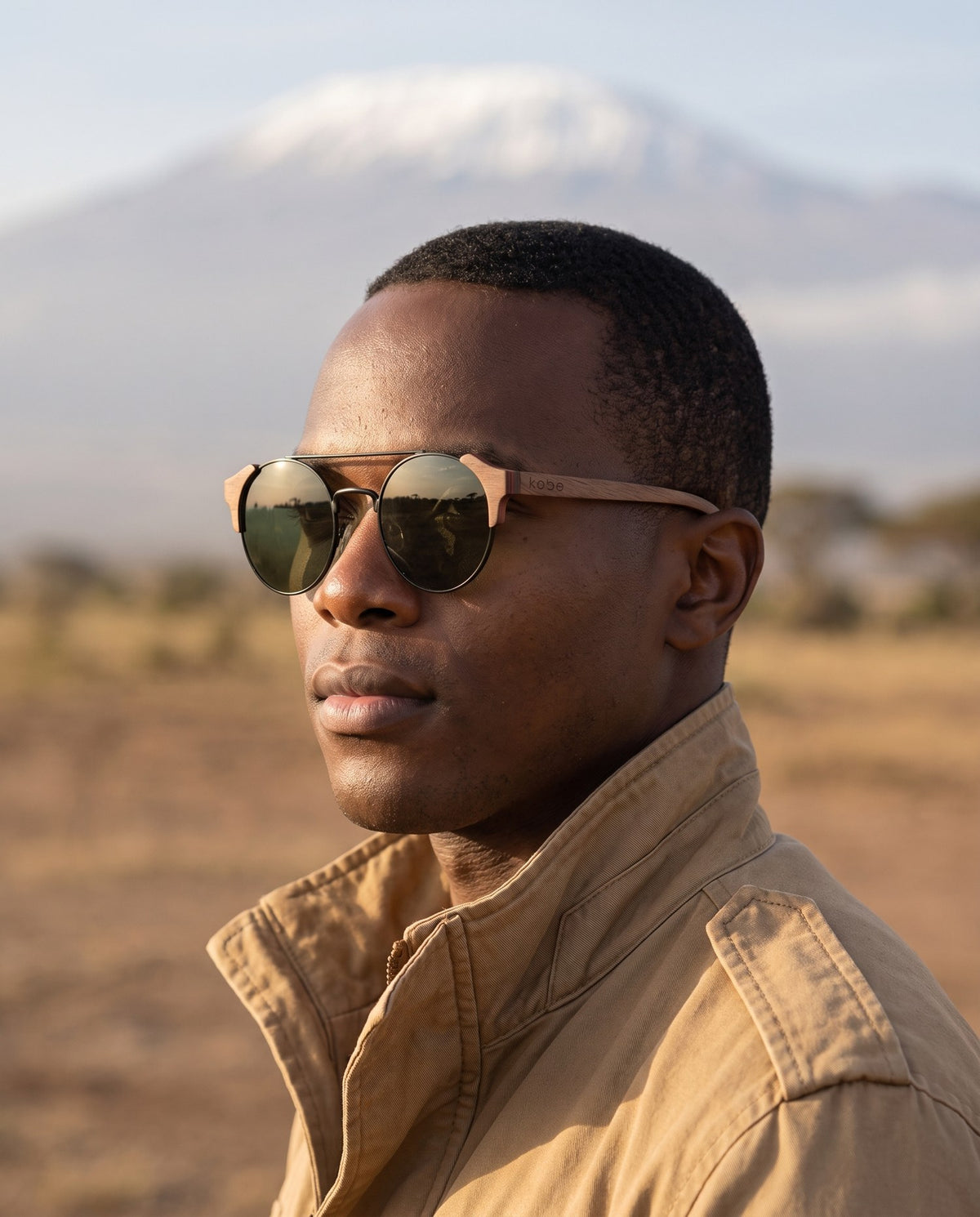 Man wearing Atacama Walnut sunglasses by Kobe Afrika below Kilimanjaro, close-up