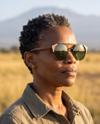 Woman wearing Atacama Walnut sunglasses by Kobe Afrika on the plains, close-up