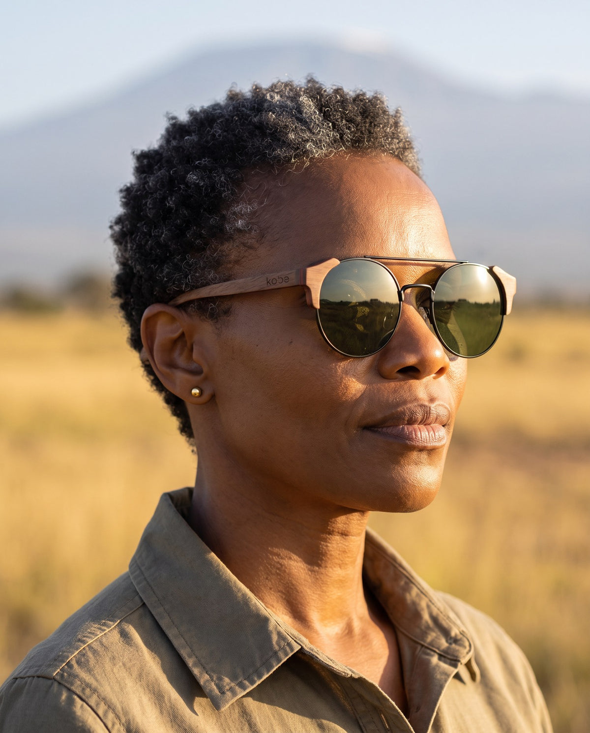 Woman wearing Atacama Walnut sunglasses by Kobe Afrika on the plains, close-up