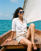 Woman sitting on the deck of a dhow in Boracay Blue sunglasses by Kobe Afrika