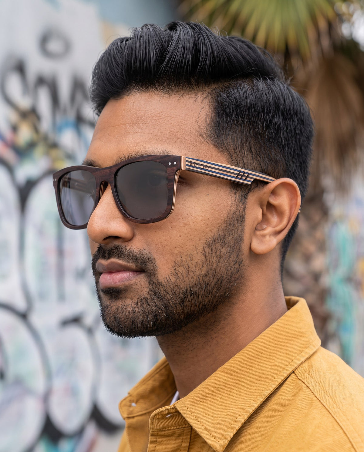 Man wearing Borneo Skate Blue sunglasses by Kobe Afrika, close-up