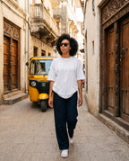 Woman walking an old-town street in Borneo Skate Blue sunglasses by Kobe Afrika