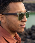 Man wearing Chalbi Green sunglasses by Kobe Afrika beside a desert lake, close-up