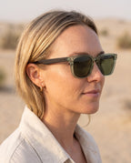 Woman wearing Chalbi Green sunglasses by Kobe Afrika in the desert, close-up
