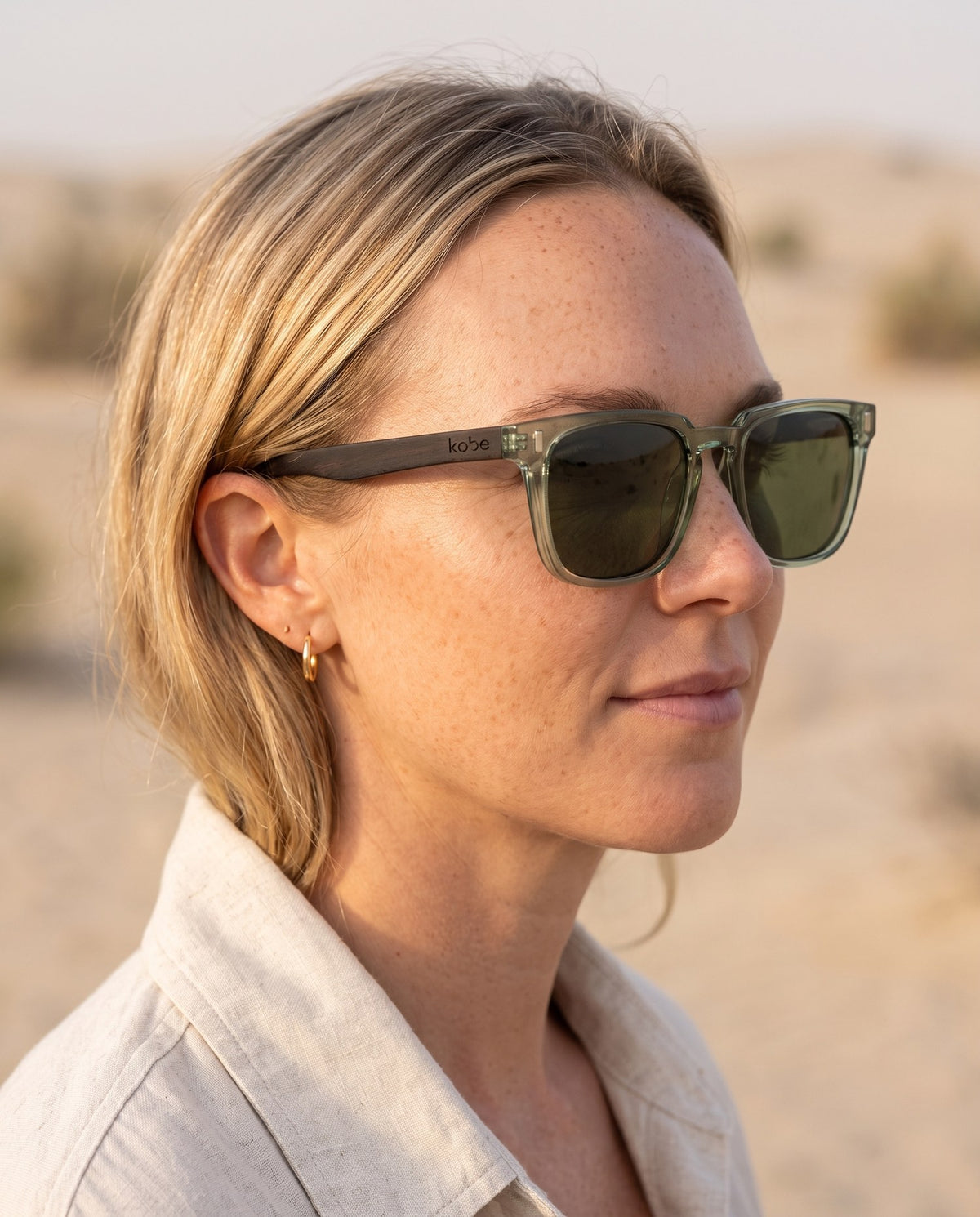Woman wearing Chalbi Green sunglasses by Kobe Afrika in the desert, close-up