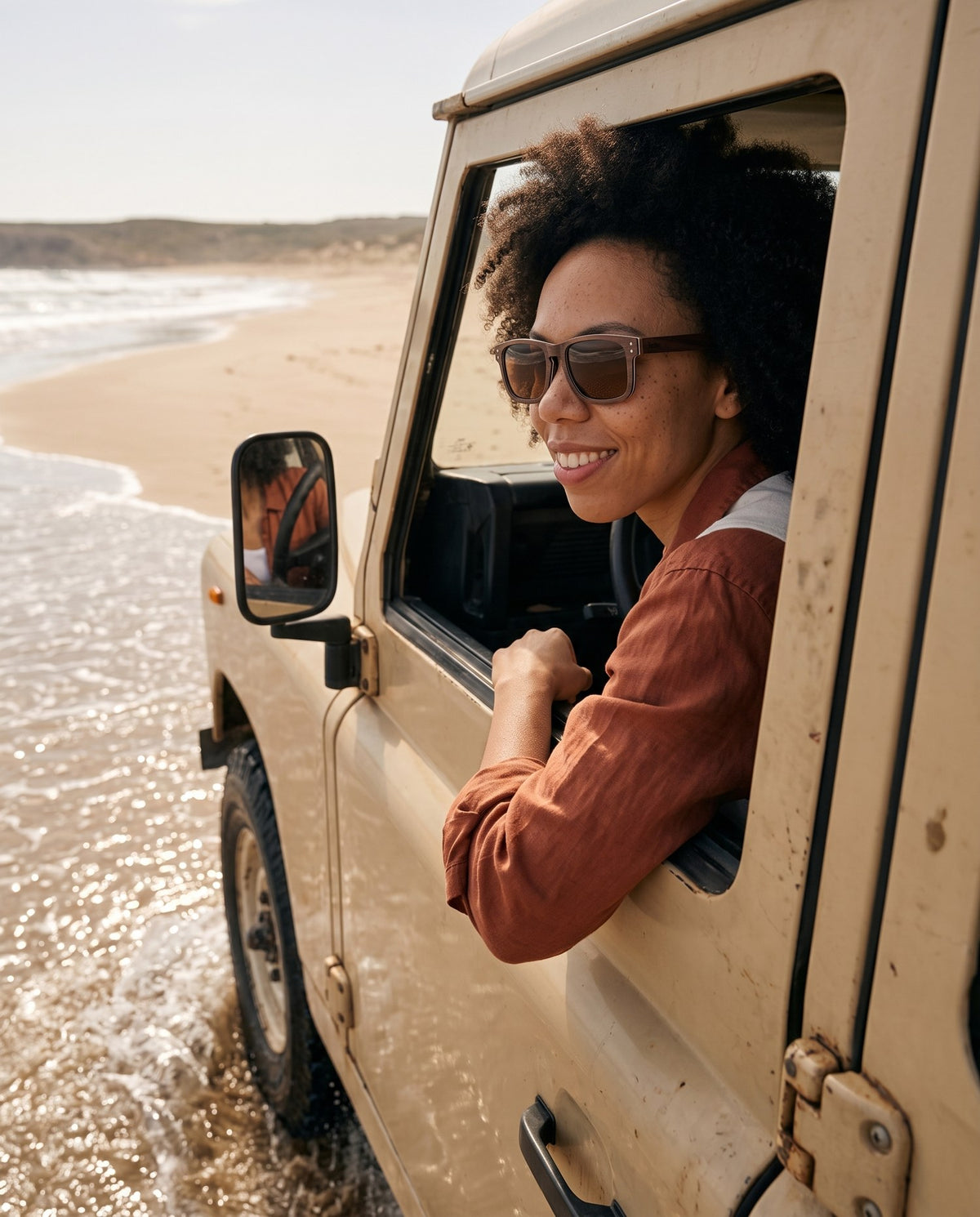 Woman driving along the beach in Fraser Walnut sunglasses by Kobe Afrika