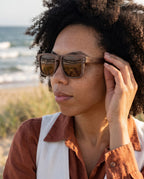 Woman wearing Fraser Walnut sunglasses by Kobe Afrika by the sea, close-up