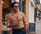 Man with coffee outside a brick street cafe in Java Walnut sunglasses by Kobe Afrika