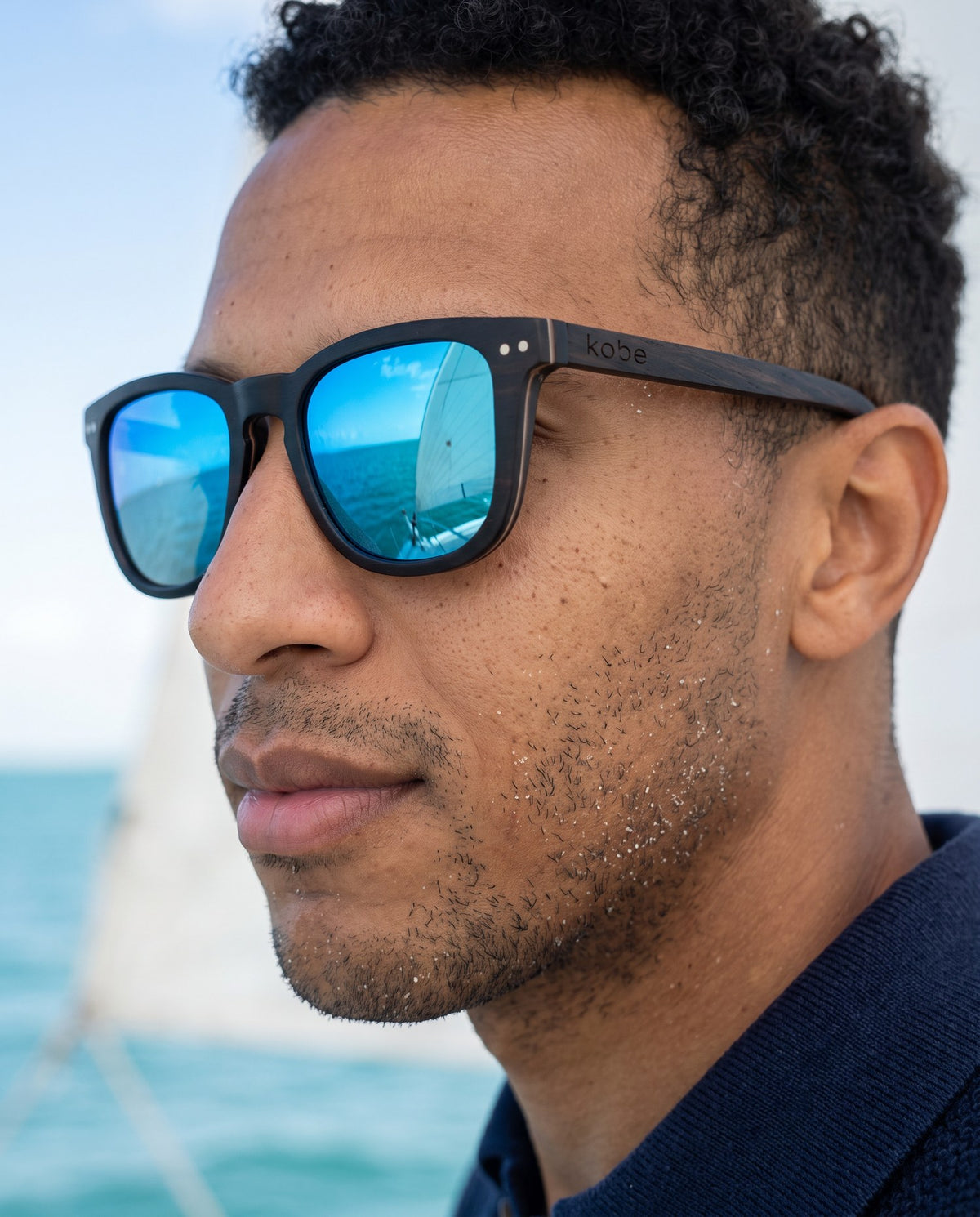 Man wearing Oahu Ocean sunglasses by Kobe Afrika by the sea, close-up
