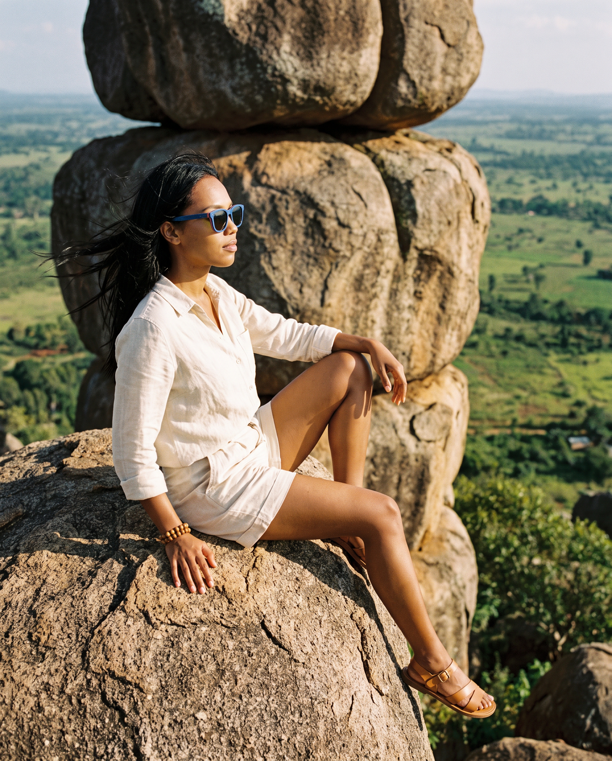 Woman sitting on granite boulders above the valley in Oahu Skate Blue sunglasses by Kobe Afrika