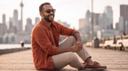 Man sitting on a waterfront boardwalk in Oahu Walnut sunglasses by Kobe Afrika