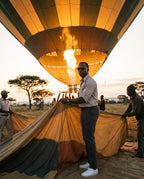 Man helping inflate a hot-air balloon at dawn in Skye Blue sunglasses by Kobe Afrika