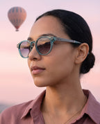 Woman wearing Skye Blue sunglasses by Kobe Afrika at dawn, close-up